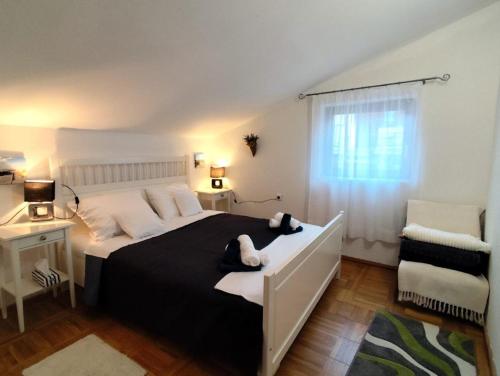 a bedroom with a black and white bed and a window at Apartment Mateo 2 mit Meeresblick und Mateo 1 mit Gartenblick in Selce