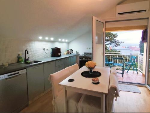 a kitchen with a table and a kitchen with a balcony at Apartment Mateo 2 mit Meeresblick und Mateo 1 mit Gartenblick in Selce