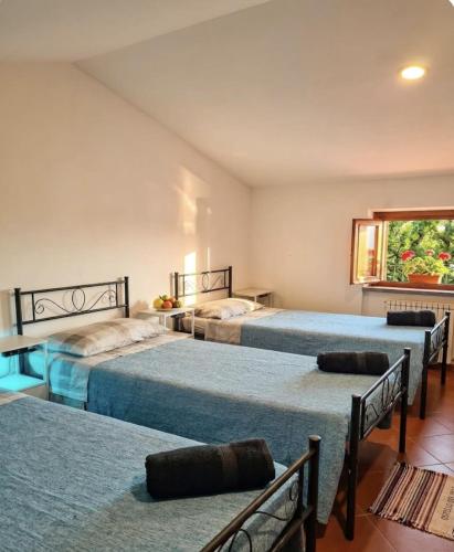 a bedroom with three beds and a window at B&B RIO GRANDE in Massarosa