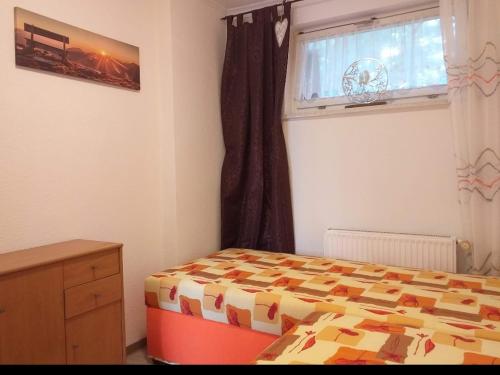 a bedroom with a bed and a window at Bungalow 2 am Donnerberg in Sewekow in Sewekow