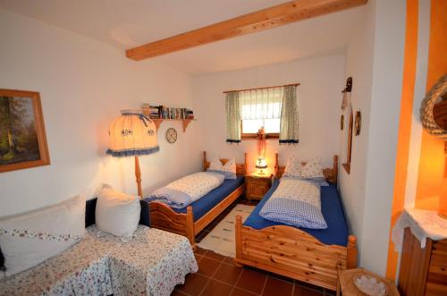 1 Schlafzimmer mit 2 Einzelbetten und einer Lampe in der Unterkunft Ferienwohnungen M Cichini in Millstatt