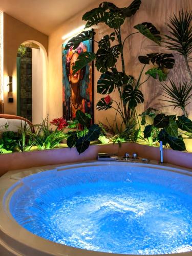 a large blue tub in a room with plants at La Casita Rosa in Valras-Plage