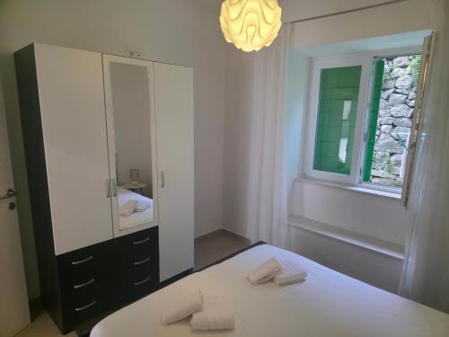 a white bathroom with a mirror and a bed at Apartman deluxe sea in Split