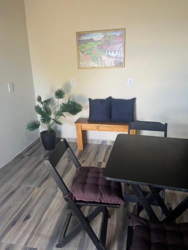 a dining room with a table and chairs and a couch at Chalé com lareira externa e vista para o Pico do Lopo in Extrema