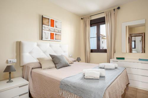a bedroom with a large bed with two towels on it at coto 4 11 in Novo Sancti Petri