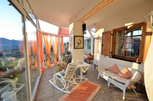 a balcony with a couch and chairs and a table at Ferienwohnungen M Cichini in Millstatt