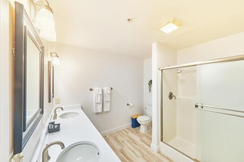 a white bathroom with a sink and a shower at Saltwater & Sunsets in Long Beach