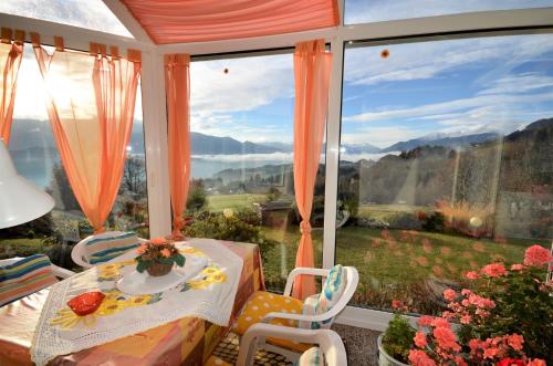 a room with a table and chairs and a large window at Ferienwohnungen M Cichini in Millstatt