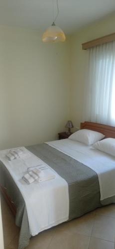 a bedroom with a large bed with white sheets at Sofia Comfort Apartment in Nivicë