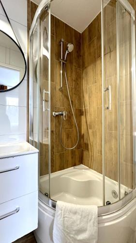 a bathroom with a shower and a bath tub at Willa Opal , 250 m do morza in Grzybowo