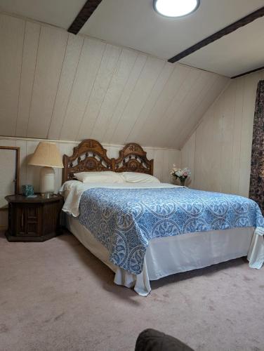 a bedroom with a bed with a blue and white comforter at Isa-e Home Stay in Hempstead