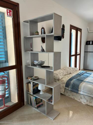a book shelf next to a bed in a bedroom at Le Persiane Azzurre est in Albiano