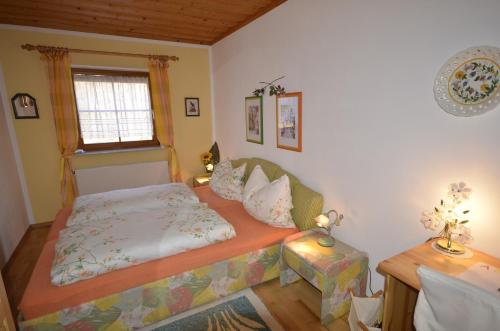 a small bedroom with a bed and a window at Ferienwohnungen M Cichini in Millstatt