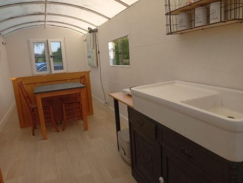a bathroom with a sink and a counter with a table at De smishoeve "Herdershut" in Heers