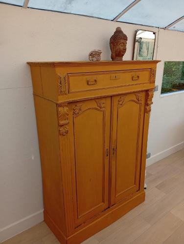 a wooden cabinet with a statue on top of it at De smishoeve "Herdershut" in Heers