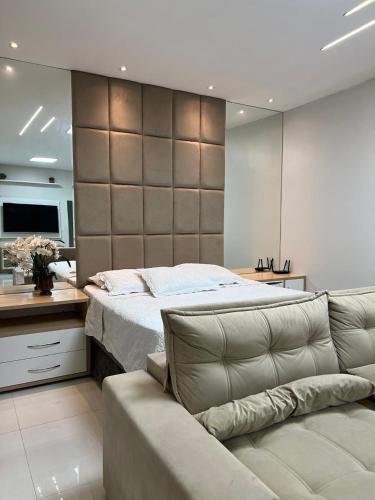 a bedroom with a large bed and a couch at Duplex mansão Manaus in Manaus
