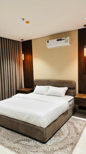 a bedroom with a large bed with white sheets at شقة أنيقة جديده في قلب أبها in Abha