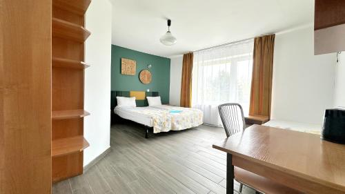 a bedroom with a bed and a table in a room at Willa Opal , 250 m do morza in Grzybowo