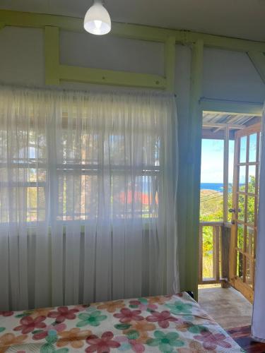 a bedroom with a bed and a window with a view at CJ's Creole Hideaway in Castries