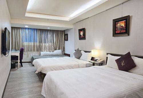 a hotel room with two beds and a television at 意芙旅店 Ifinn Hotel in Taipei