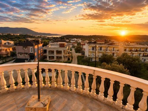 a view of a city at sunset from a balcony at Charming Apartment with Sea View in Néa Seléfkeia