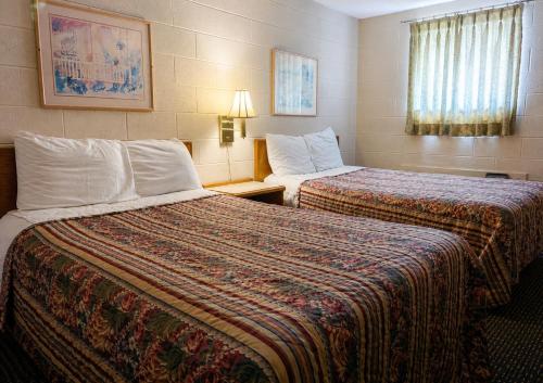 a hotel room with two beds and a window at Skyline Motel Bartlesville Hwy 75 in Bartlesville