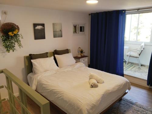 ein Schlafzimmer mit einem Bett, auf dem ein Handtuch liegt in der Unterkunft Green gallery in Haifa