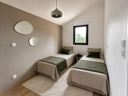 two beds in a room with two mirrors at Le Petit Chalet in Crolles