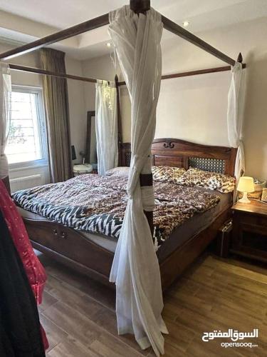 a bedroom with a canopy bed in a room at عمان - ضاحية النخيل in Amman