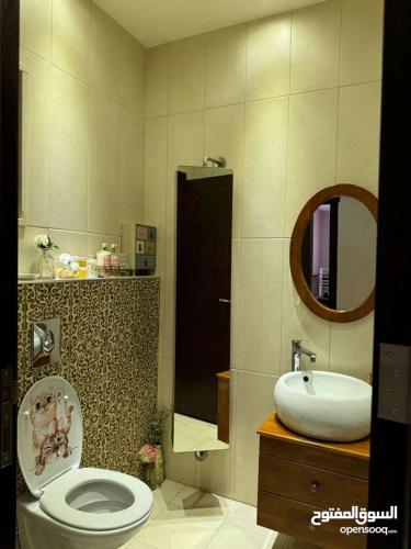 a bathroom with a toilet and a sink at عمان - ضاحية النخيل in Amman