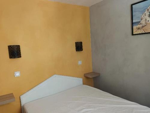 een slaapkamer met een wit bed in een kamer bij le dramont in Saint-Raphaël