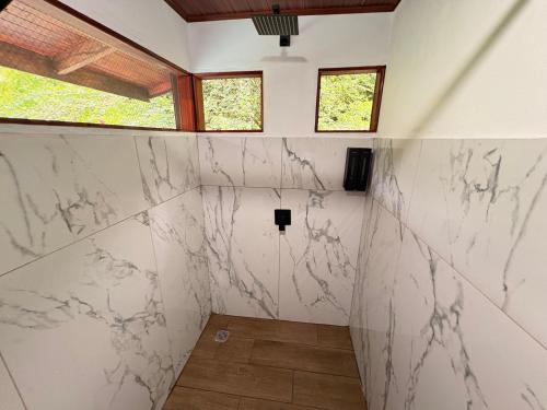a bathroom with white marble walls and windows at Pacheco Villa in Drake