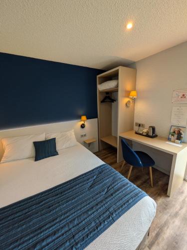 a hotel room with a bed and a desk and a bed and a desk at Brit Hotel Argentan in Argentan