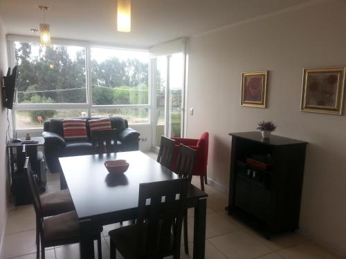 a living room with a table and chairs and a window at Condominio Lomas de Papudo I in Papudo