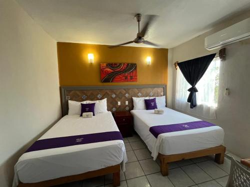 a bedroom with two beds and a window at Bungalows Yeah Los Ayala in Los Ayala