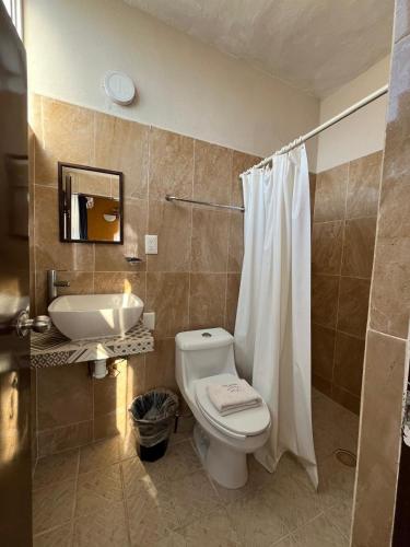 a bathroom with a toilet and a sink at Bungalows Yeah Los Ayala in Los Ayala