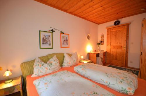 a bedroom with a bed and a couch with pillows at Ferienwohnungen M Cichini in Millstatt