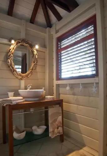 a bathroom with a sink and a mirror at Villa Vigie in Deshaies