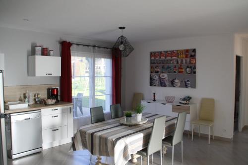 une cuisine et une salle à manger avec une table et des chaises dans l'établissement Gîte de Roches Hibou, à Seigy