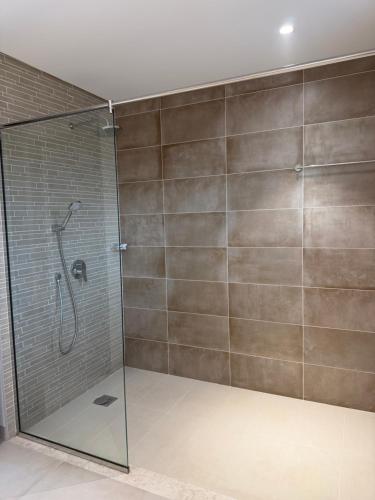 a shower with a glass door in a bathroom at Beach front 414 villa private pool in Muscat
