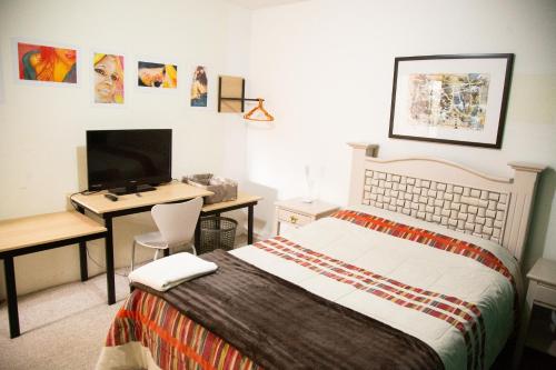 a bedroom with a bed and a desk with a computer at Casa del Horno in El Cinco de Mayo