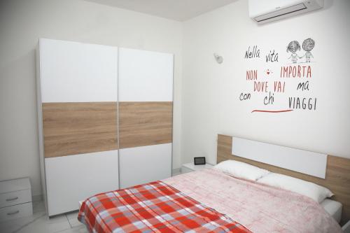 a bedroom with a bed and a wall with writing on it at Ama affittacamere in Gleris