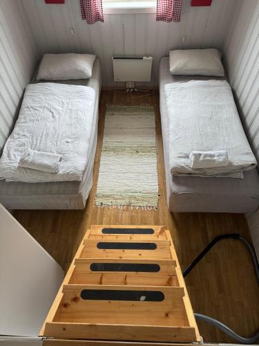 a small room with two beds and a wooden floor at Lysø naturcamping og rorbuer in Averoy