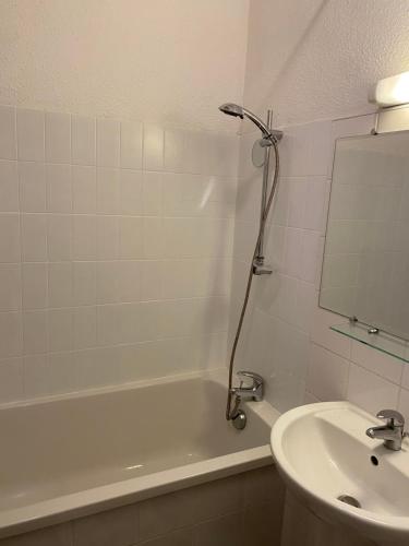 a bathroom with a tub and a sink and a mirror at Azurea in Saint-Cyr-sur-Mer