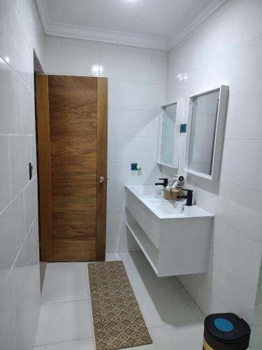 a bathroom with a sink and a wooden door at Beautiful View Apartment in San Pedro de Macorís