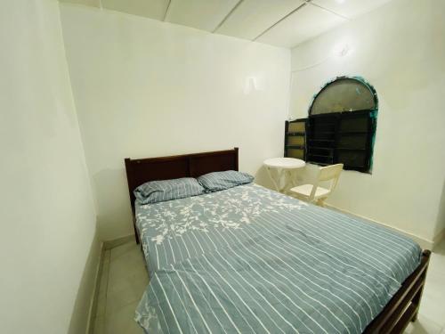 a bedroom with a bed and a table and a mirror at Casa Edi Hostal Santa Marta in Santa Marta