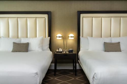 a hotel room with two beds and a table with a lamp at Hotel Commonwealth in Boston