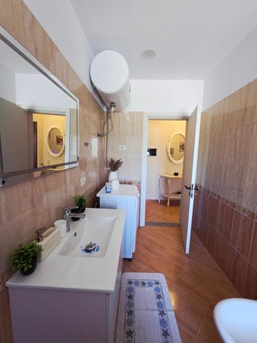 a bathroom with a white sink and a mirror at Asea Apartaments in Golem