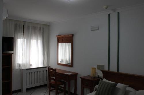 a room with a bed and a desk and a window at La Posada del Conde in Ardales
