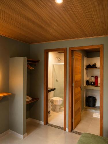 a bathroom with a toilet and a wooden ceiling at Casas de Juan in Morro de São Paulo
